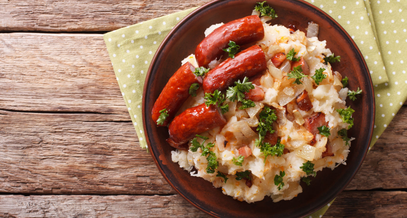 Dutch winter meal: stamppot of potatoes, cabbage and carrots, with sausages close-up on a plate [Photo: Shutterstock]