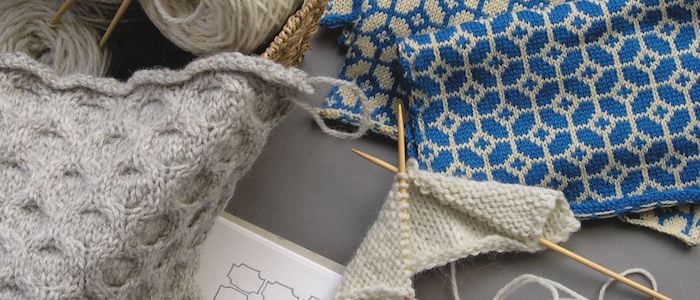 A selection of knitting equipment and knitted pattern samples