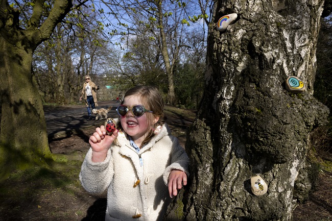 Millie Gilmartin (age 4) from Glasgow discovers some painted pebbles while walking in the park with her mum Emma and Rafa the dog. Photo credit Martin Shields