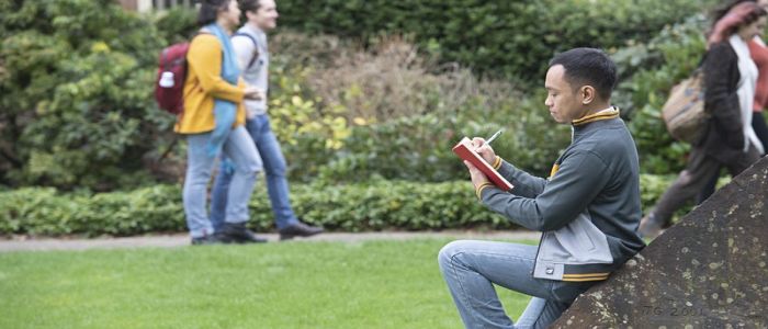 Student studying outside on the grass