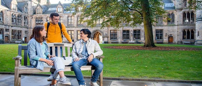 Students sitting on a bench on campus