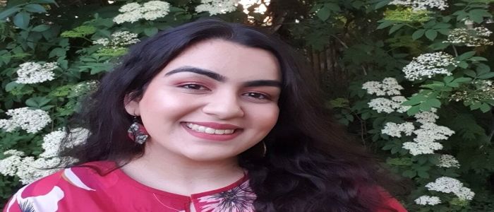 Student girl smiling in front of flowers