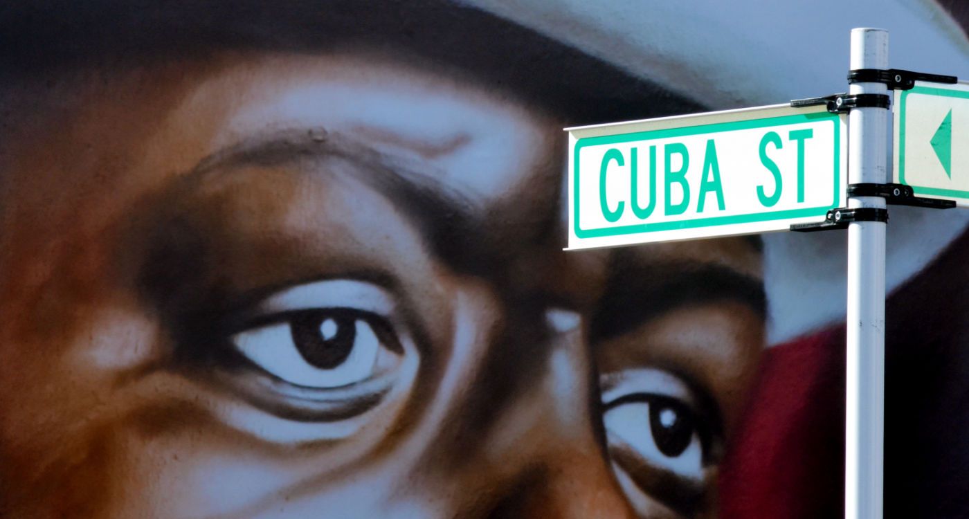 Cuba Street signpost with a mural of a man's face in the background [Photo: Shutterstock]