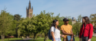 Image of UofG students standing together with the University of Glasgow tower in the background. Image was used for the Decolonising the Curriculum event at UofG