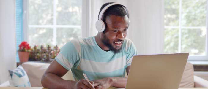 Student wearing headphones studying on a laptop
