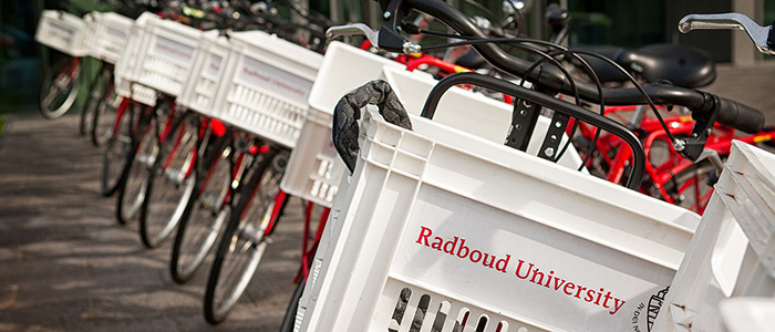 Close up of a basket on the front of a bicycle, branded with the Radboud University logo