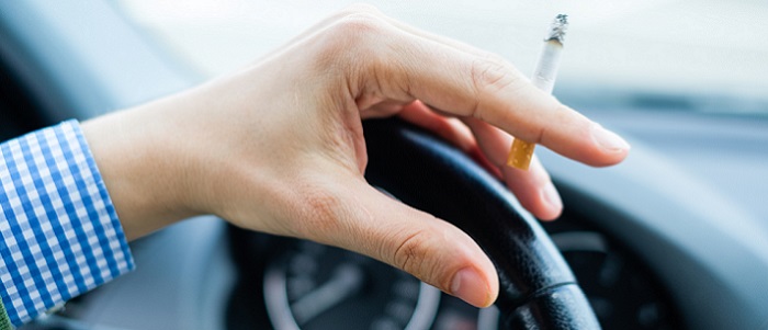 Person holding a cigarette while in a vehicle