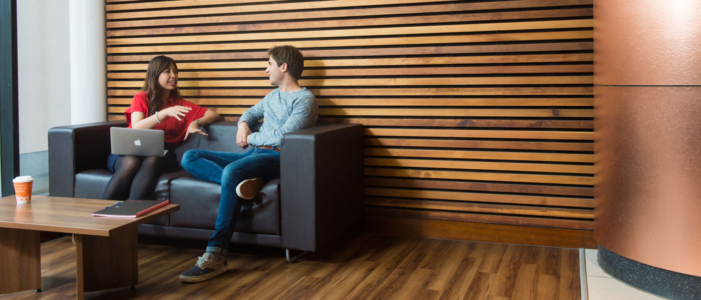 Photo of man and woman chatting in library