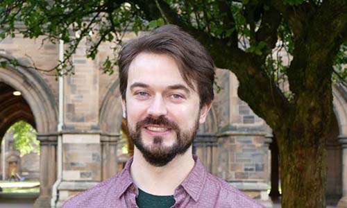 Student adviser Stephen is standing in the quads of the University of Glasgow, smiling and looking to camera.