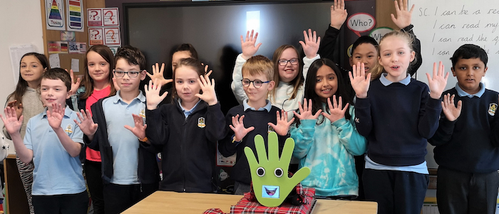 Pupils from Broomhill Primary School pose with handwashing robot WallBo