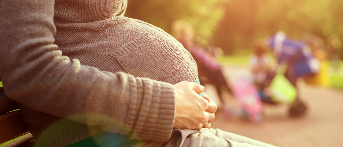 Photo of pregnant woman sitting on a park bench