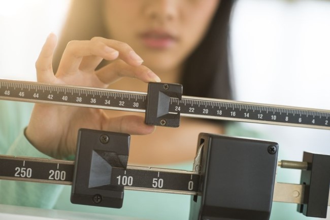 Image of a doctor checking scales for a patient's weight