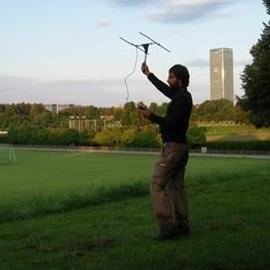 Researcher using drone as a telemetry device with urban skyline in background