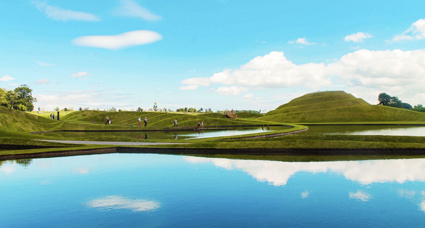 People walking amongst the hilly green landscape of Jupiter Artland [Photo: Shutterstock]