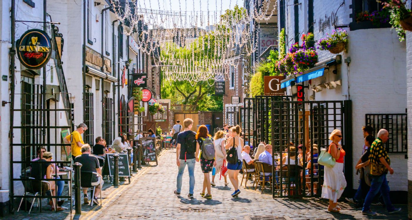 View of people walking down and sitting outside venues in Ashton Lane [Photo: Glasgow Life]