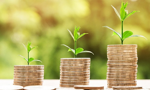 Three piles of coins of different heights on a green background