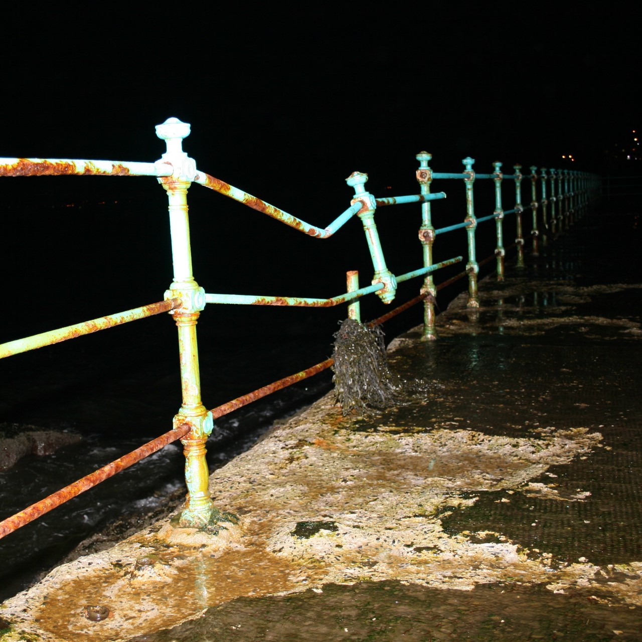 Rusty railings on a promenade in Gourock at night