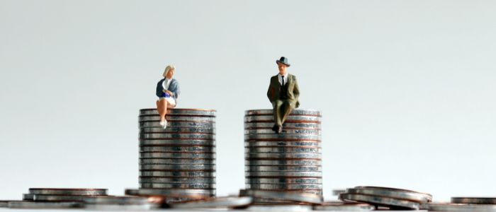 Image of male and female figurines sitting on a stack of coins