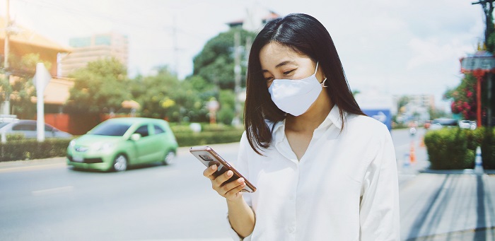 Woman wearing a face mask and looking at her phone