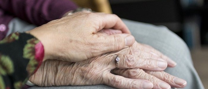 Image of a hand holding the hand of an elderly person