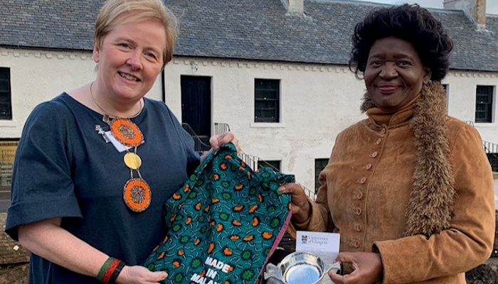 An image of Alex Mackay and the First Lady of Malawi standing together during the presentation of the UofG quaich