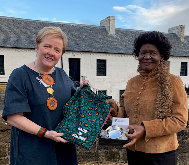 An image of Alex Mackay and the First Lady of Malawi standing together during the presentation of the UofG quaich 