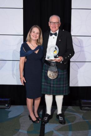 Gregor Reid holding Dr Rogers Prize, alongside his wife.
