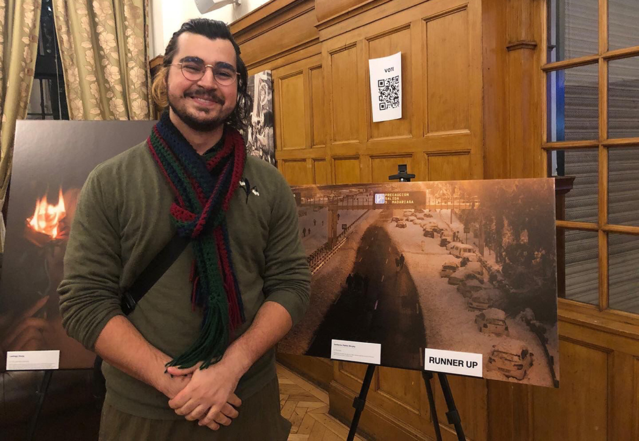 Guillermo Pablos Murphy standing beside his winning photograph of Pedestrians and piled up cars on a major Spanish highway during the Filomena storm 