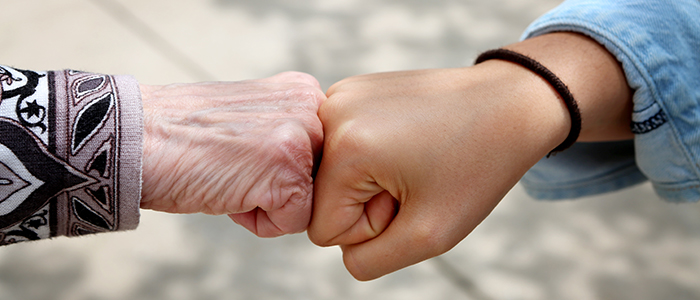 Young and old woman are fist bumping, young and old ethnic contest