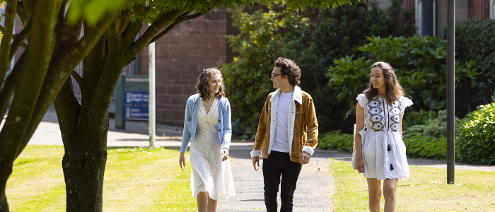 Students walking through trees - 700x300