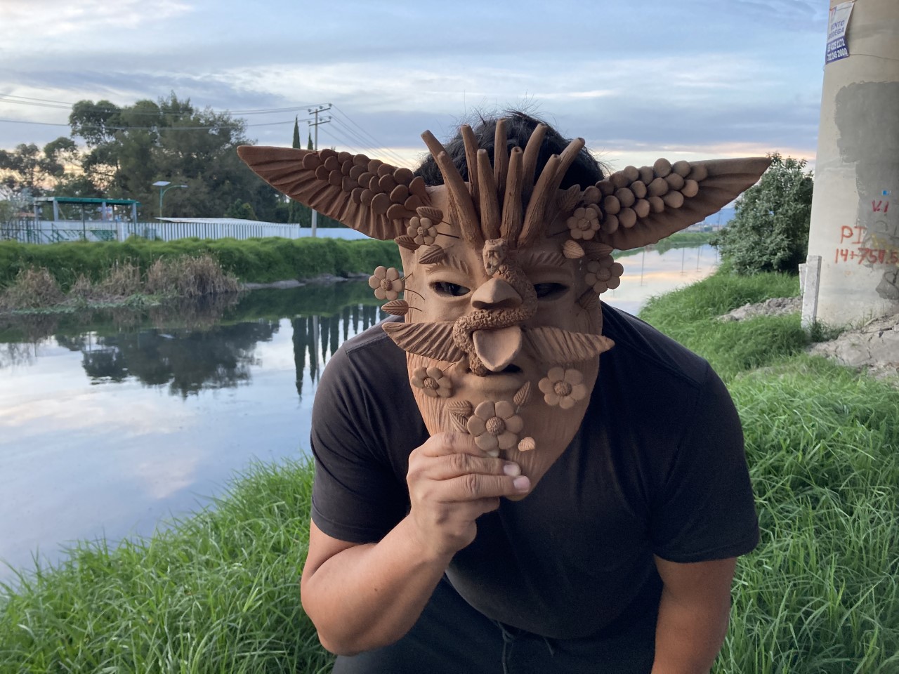Man with Mexican indigenous mask by river
