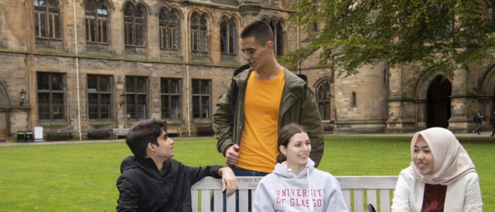 Group of students sitting on a bench in the quadrangle 