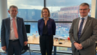MSPJenny Gilruth standing in the SGDB with window behind, flanked by Professor Sir Anton Muscatelli and Professor Paul Garside