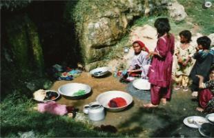 Village women washing clothes in spring water.  Non-availability of clean water is a central issue for most rural communities in developing countries.