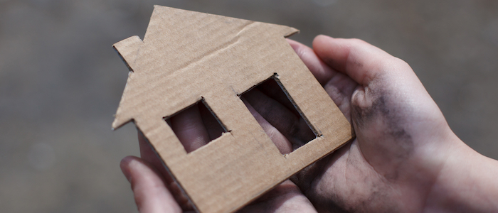 cardboard cutout house held in hands