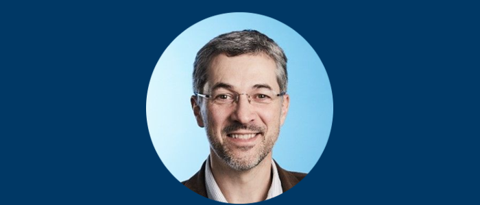 A head and shoulders shot of Professor Kevin Maloy in a cropped off circle with blue background