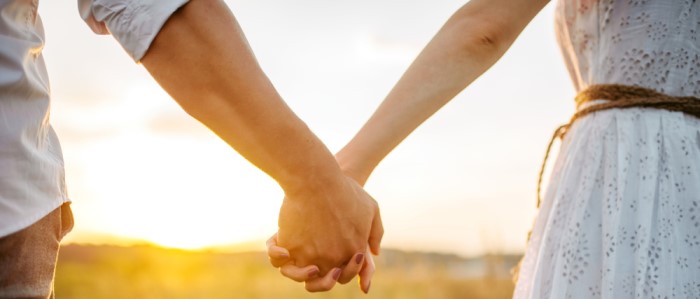 Image of a couple holding hands outdoors