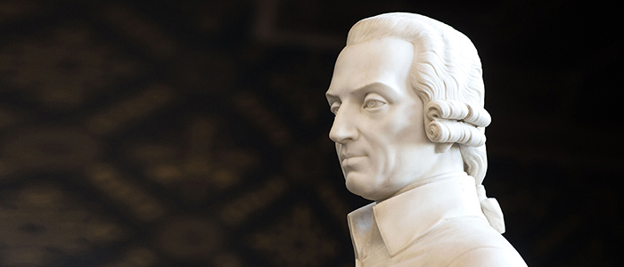 Close up of the face of the Adam Smith statue at the University of Glasgow, from the side with a black background