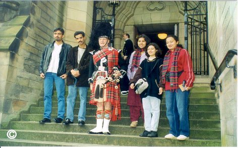 Visiting students with a Scottish Piper on the steps of Glasgow University Chapel, March 2003