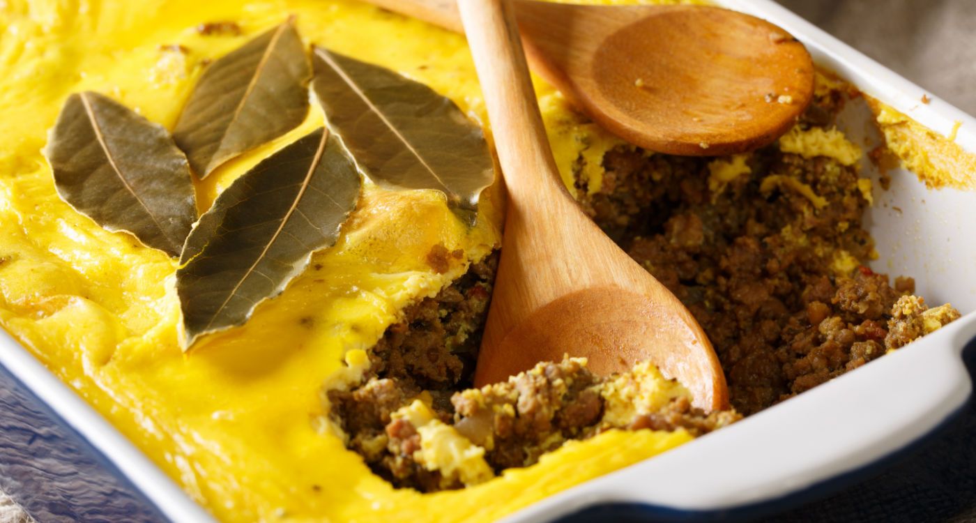 Close up of bobotie, a South African dish made primarily of curried minced meat topped with milk and egg mixture [Photo: Shutterstock]