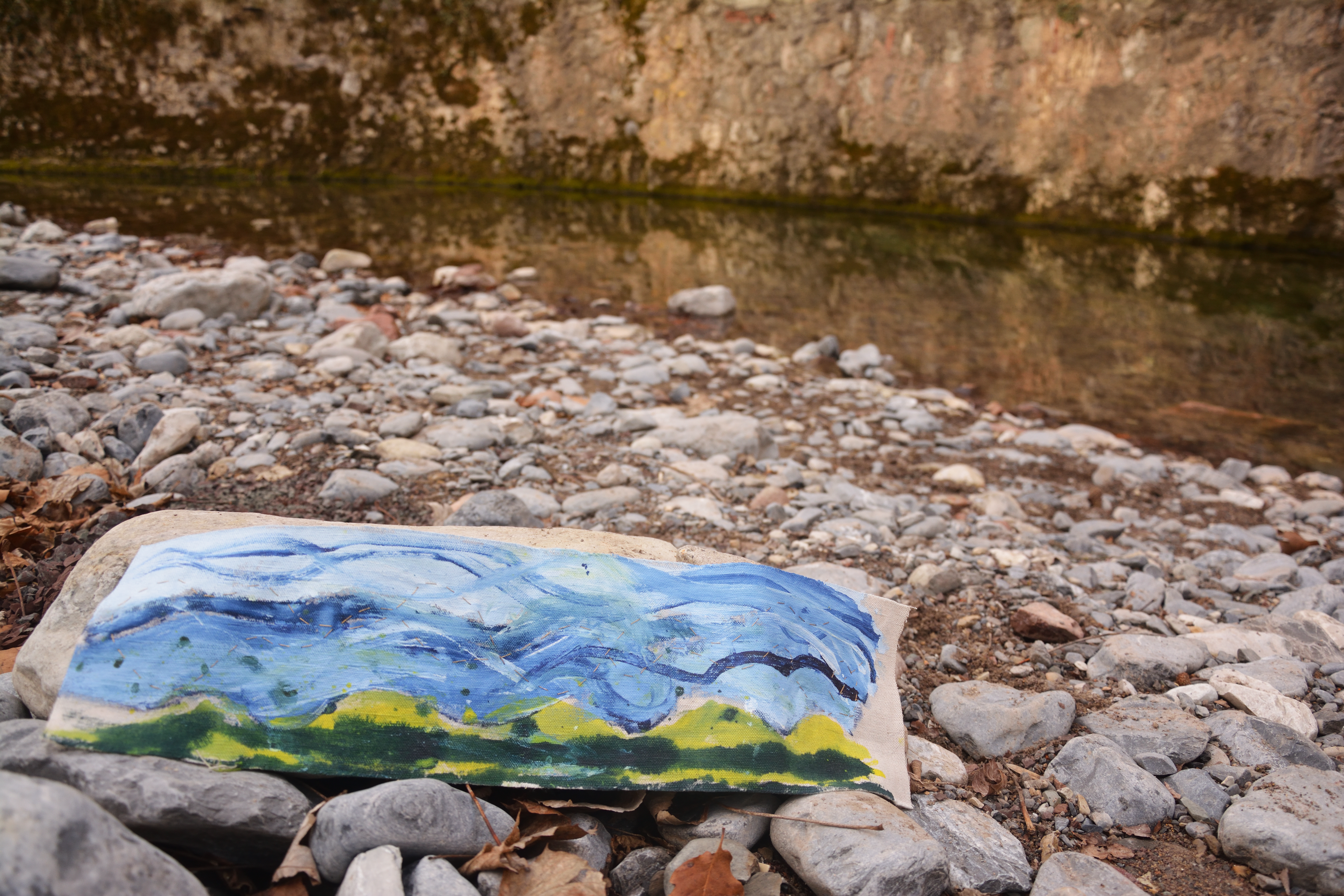 Painting laid beside a river