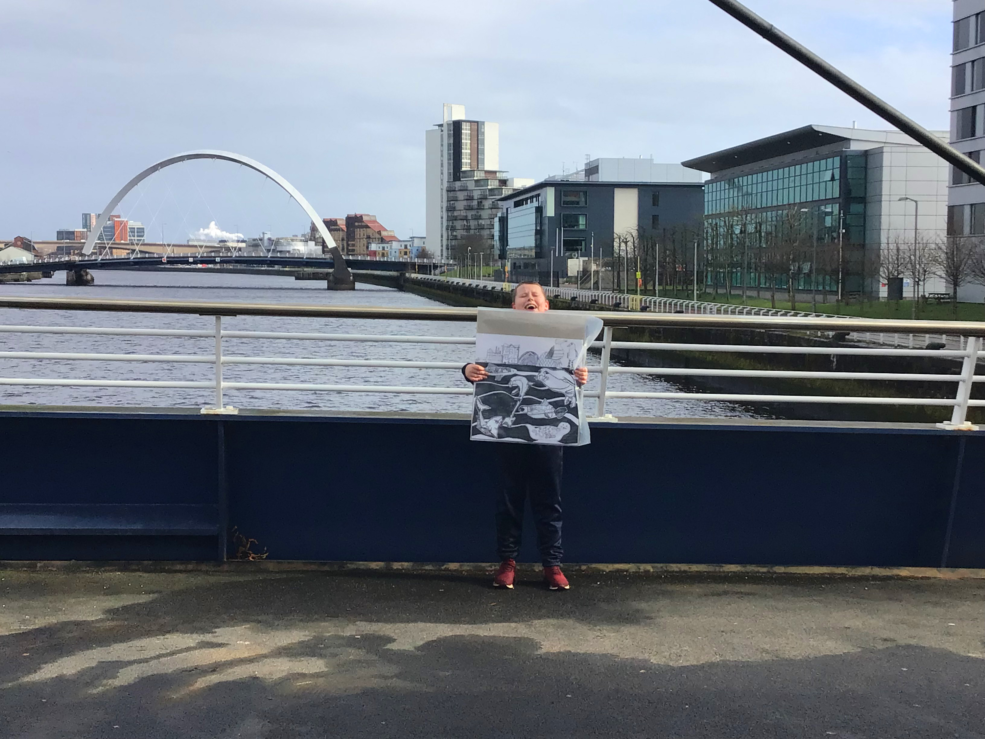 One child holding an artwork at the river clyde