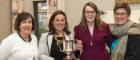 Four women standing with trophy