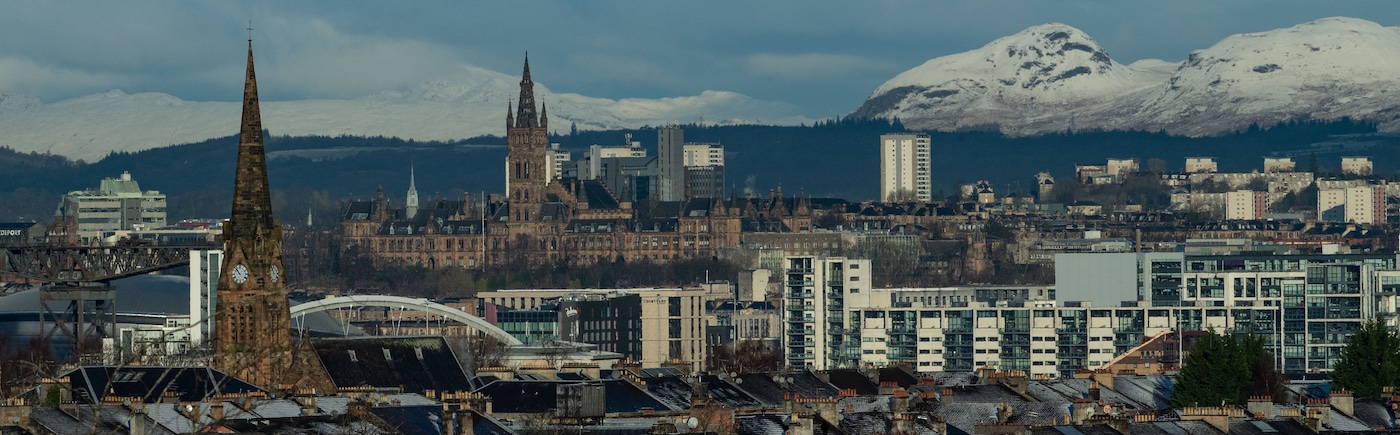 city scape view of glasgow with snowycapped mountains