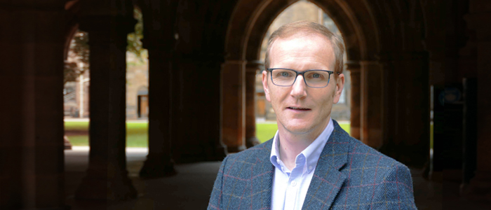 Professor Graeme Roy standing in the University of Glasgow cloisters