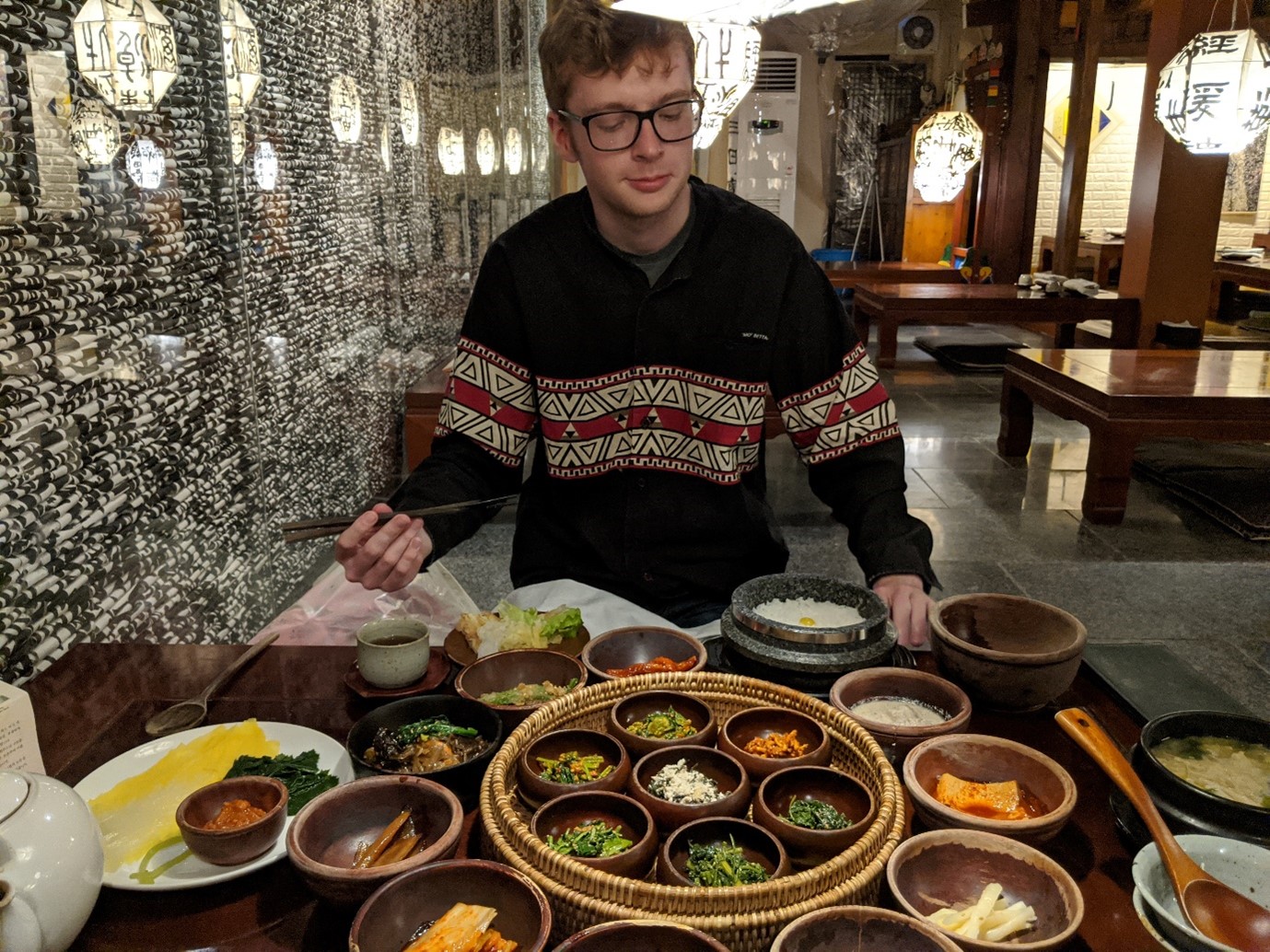 Calum Bell at a Buddhist vegetarian restaurant in South Korea with plates of food