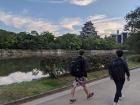 A photo of two students walking away towards Hiroshima Castle