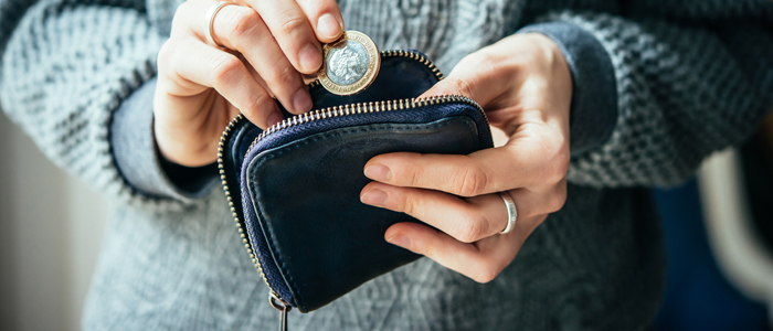 Close up of a person putting a coin into a purse
