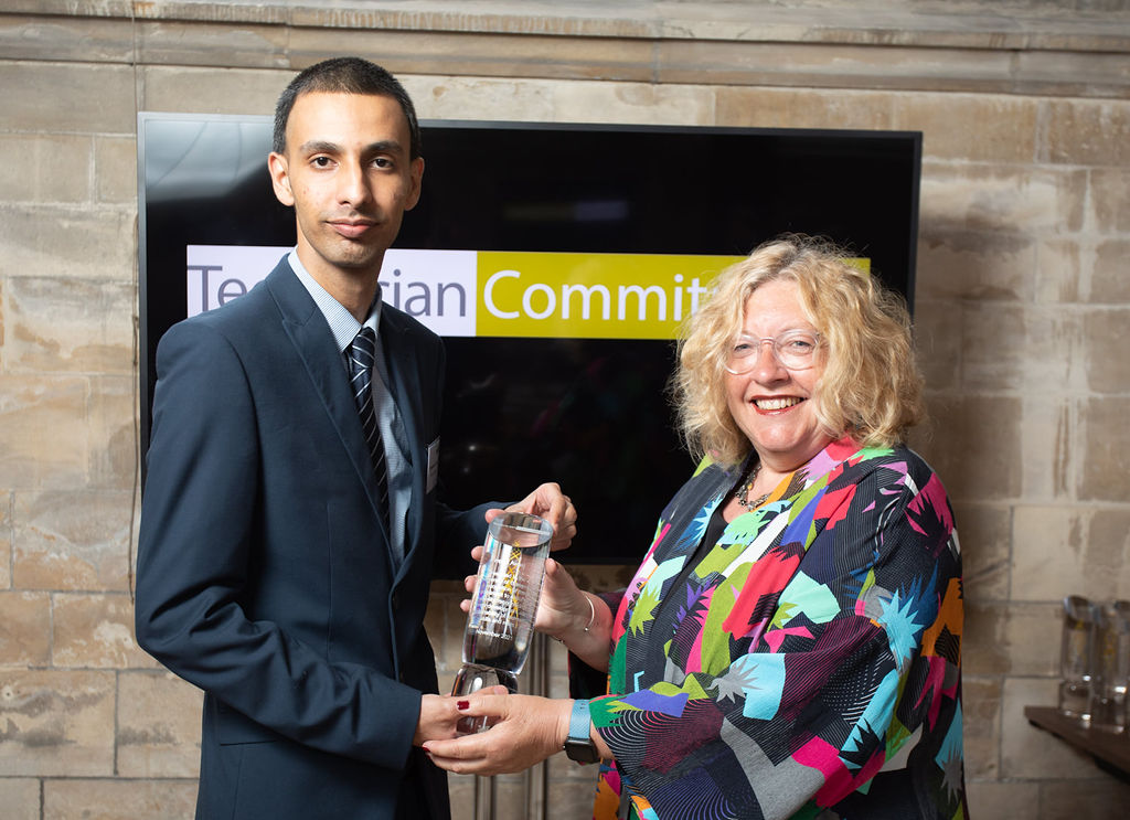 Ali Salik receiving an award from Technician Commitment