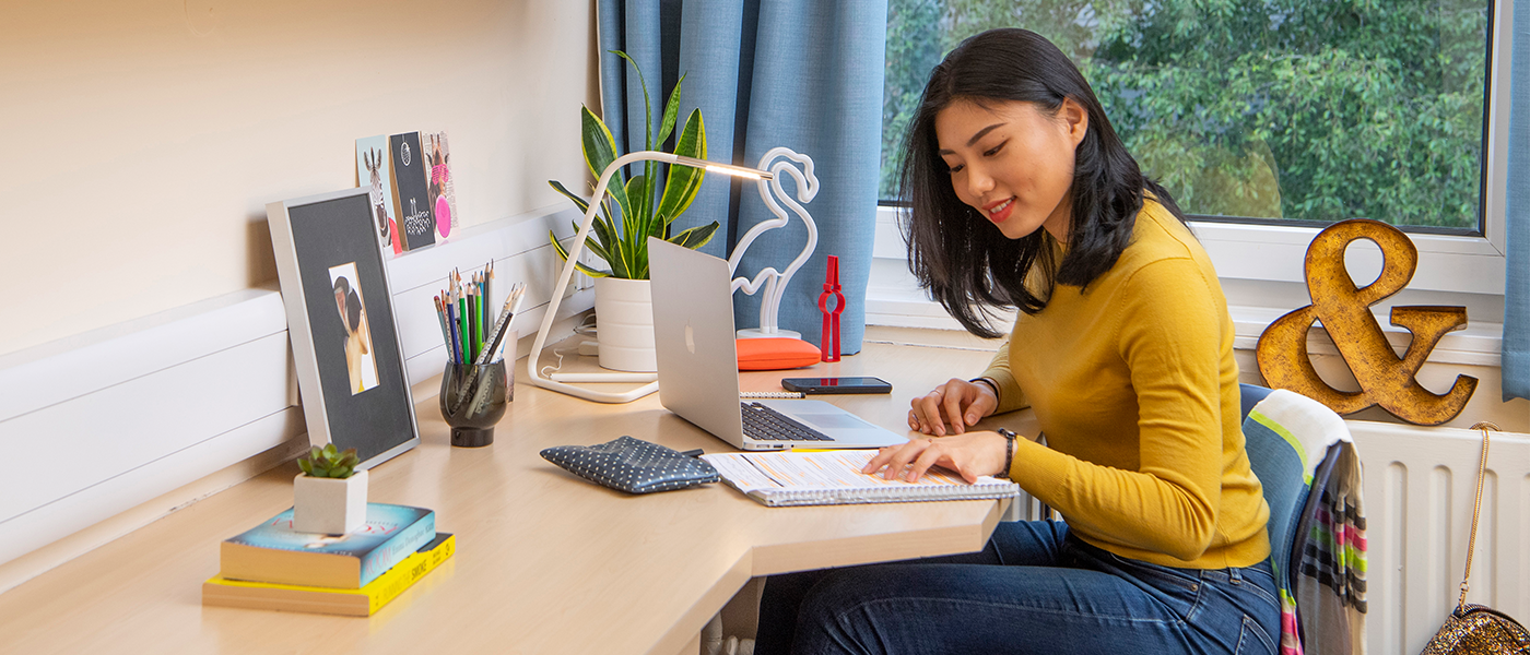 Student sitting at her desk in her halls of residence